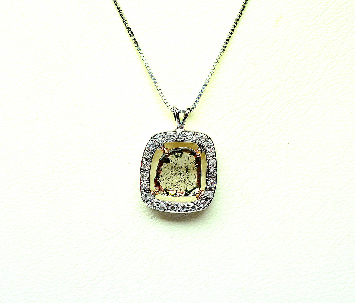 White gold and rose gold bicolour pendant, centred with a flat faceted diamond of Natural colour weighing 1 c approx in a setting of 23 white diamonds. Gold 2,47 g